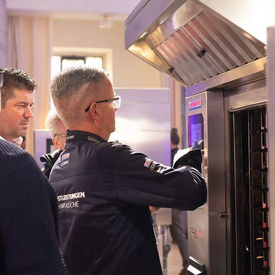 Professional kitchen scene with HOBART appliance – person interacting with the device via touchscreen