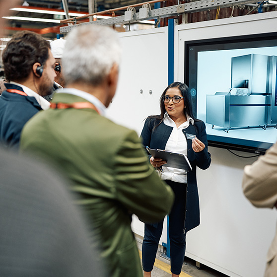 Technical presentation of a HOBART device to a group in an industrial setting with screen and tablet