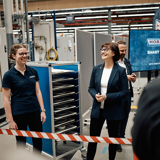 Presentation of the HOBART SMART LOAD system in an industrial setting with participants in front of shelving and screen