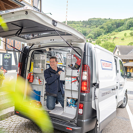 Service van with HOBART logo and open doors, equipped with tools and shelves for field operations.