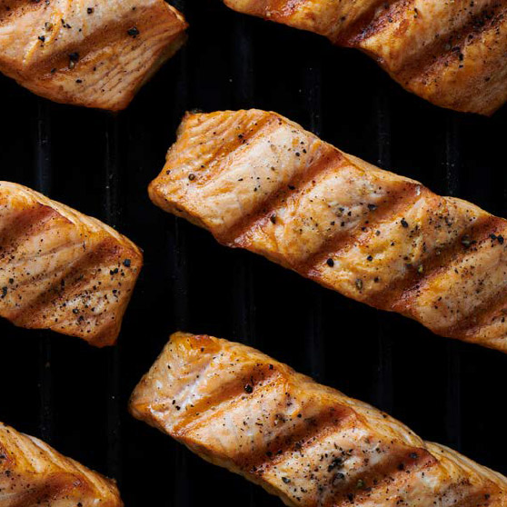 Grilled salmon fillets with distinct grill marks and seasoning – perfectly cooked using HOBART's CHEF'S COMBI for even and professional grilling results.