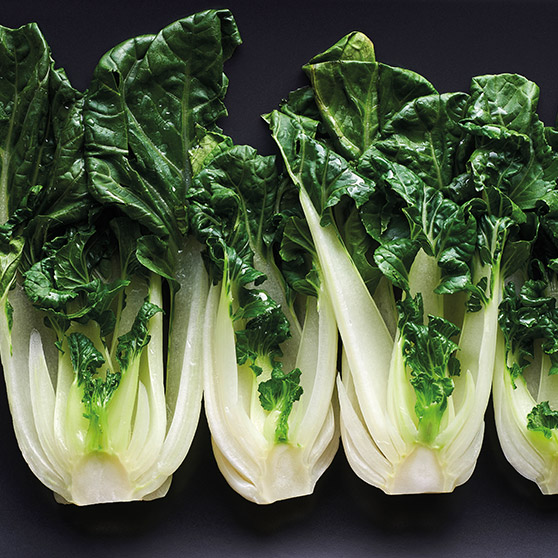 Four fresh bok choy heads with white stalks and green leaves – gently cooked using HOBART's CHEF'S COMBI to preserve freshness and nutrients.