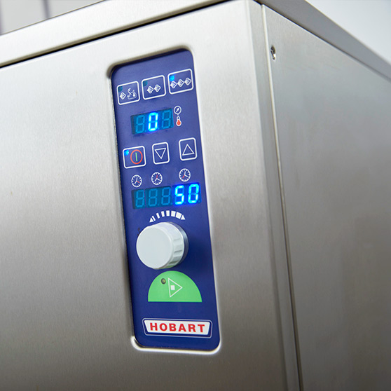 Close-up of the control panel of a HOBART dry steam high-speed cooker with digital display, rotary knob and start symbol, modern stainless steel design for professional cooking technology.