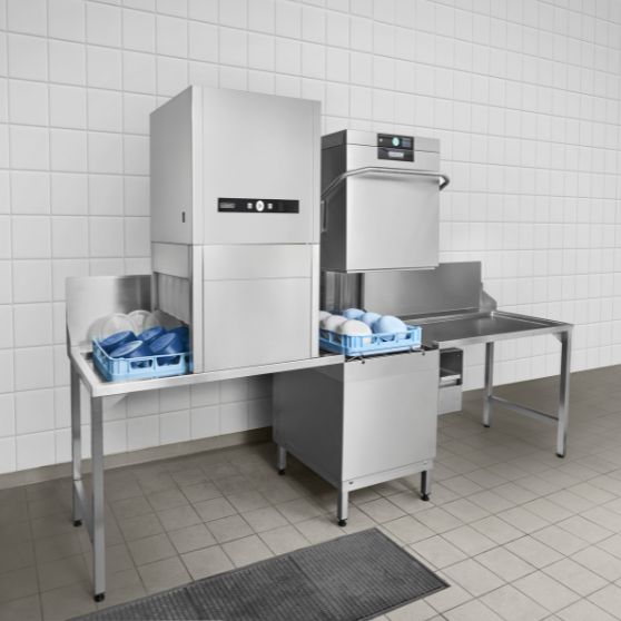 HOBART hood-type dishwasher with external drying solution in a professional dishwashing area, perfect for catering and large kitchens, featuring stainless steel tables, dish racks, energy-efficient technology, and hygienic washing for spotless results.