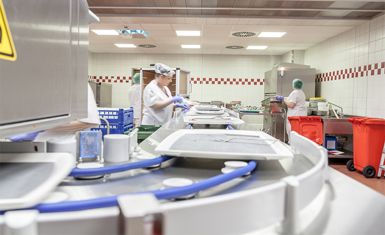 Modern dishwashing area with HOBART FLOW Line autoLINE, automatic washing system featuring conveyor and workstations for efficient cleaning of trays, plates and glasses, stainless steel design for hygienic and optimized workflows.