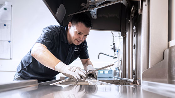 HOBART Service performing thorough cleaning and maintenance of a commercial dishwasher, ensuring hygiene, care, and reliable operation for professional dishwashing systems.